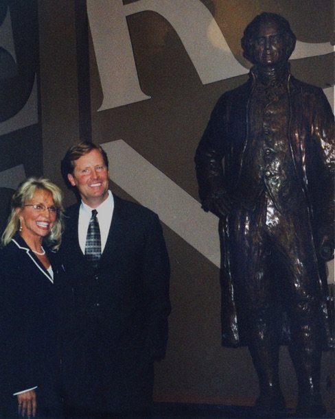 A man and woman standing in front of a statue.