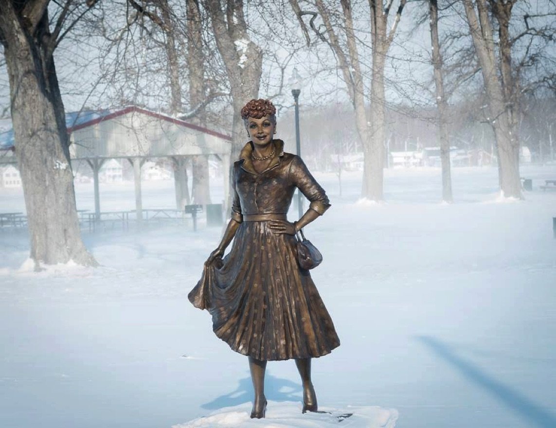 A statue of a woman in a dress and hat.