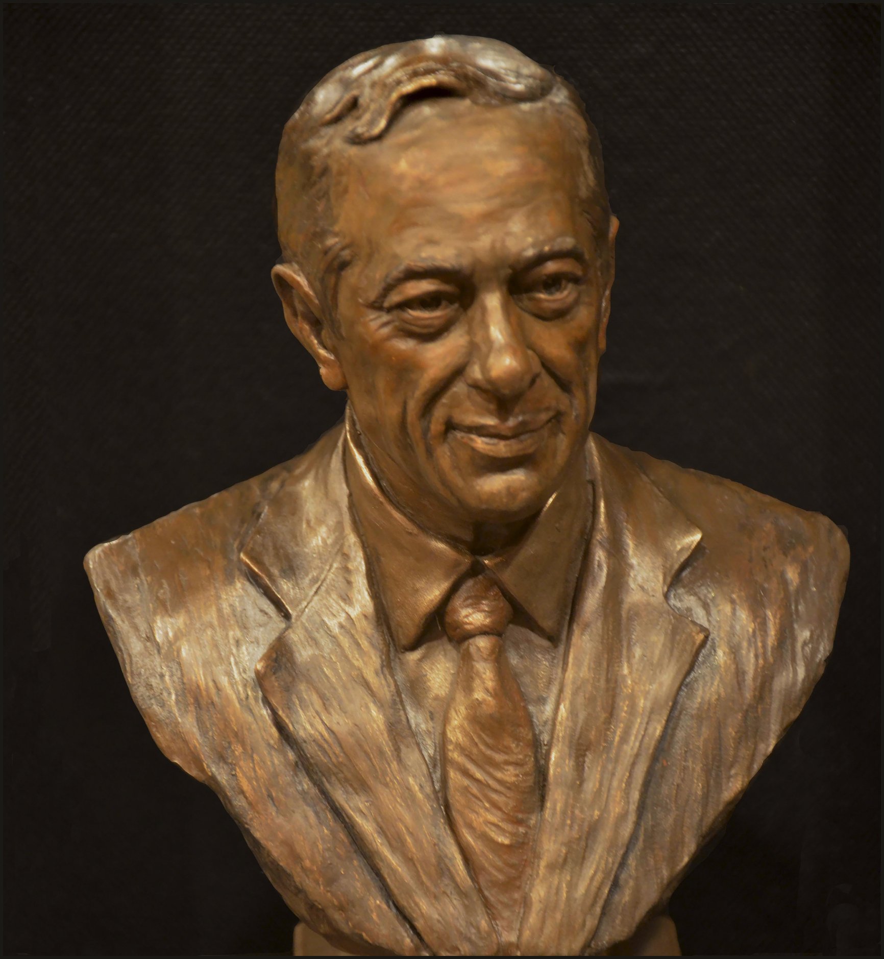 A bust of a man in suit and tie.