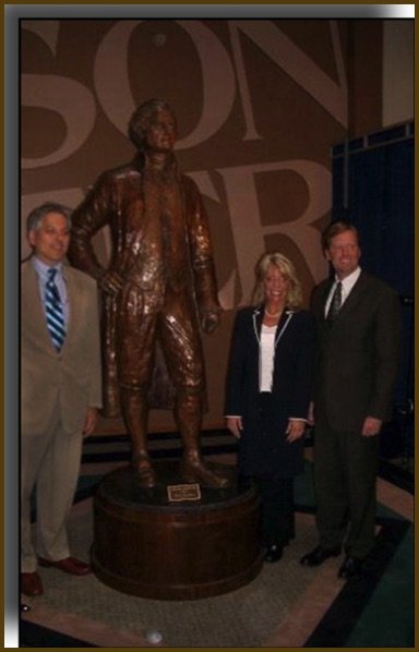 A group of people standing next to a statue.