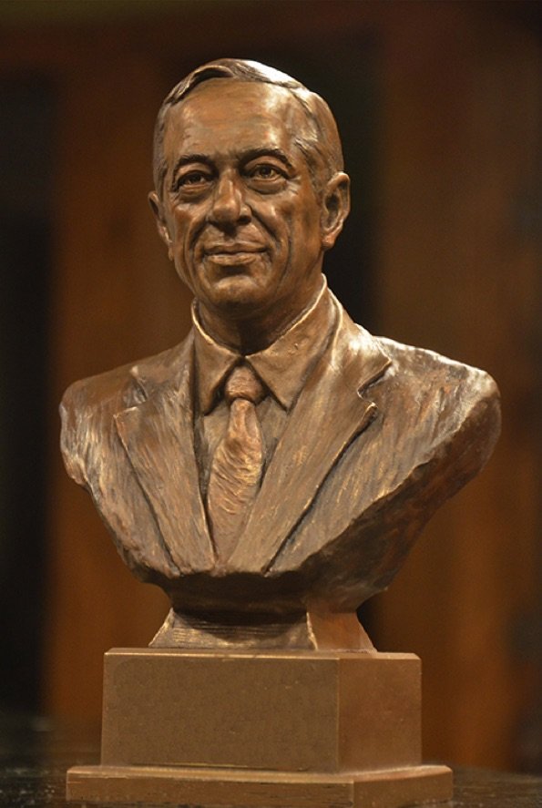 A bust of an older man wearing a suit and tie.