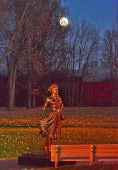 A woman in a dress is walking on the grass