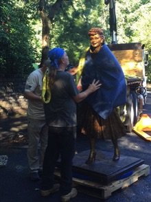 A man in a blue blanket standing next to a woman.