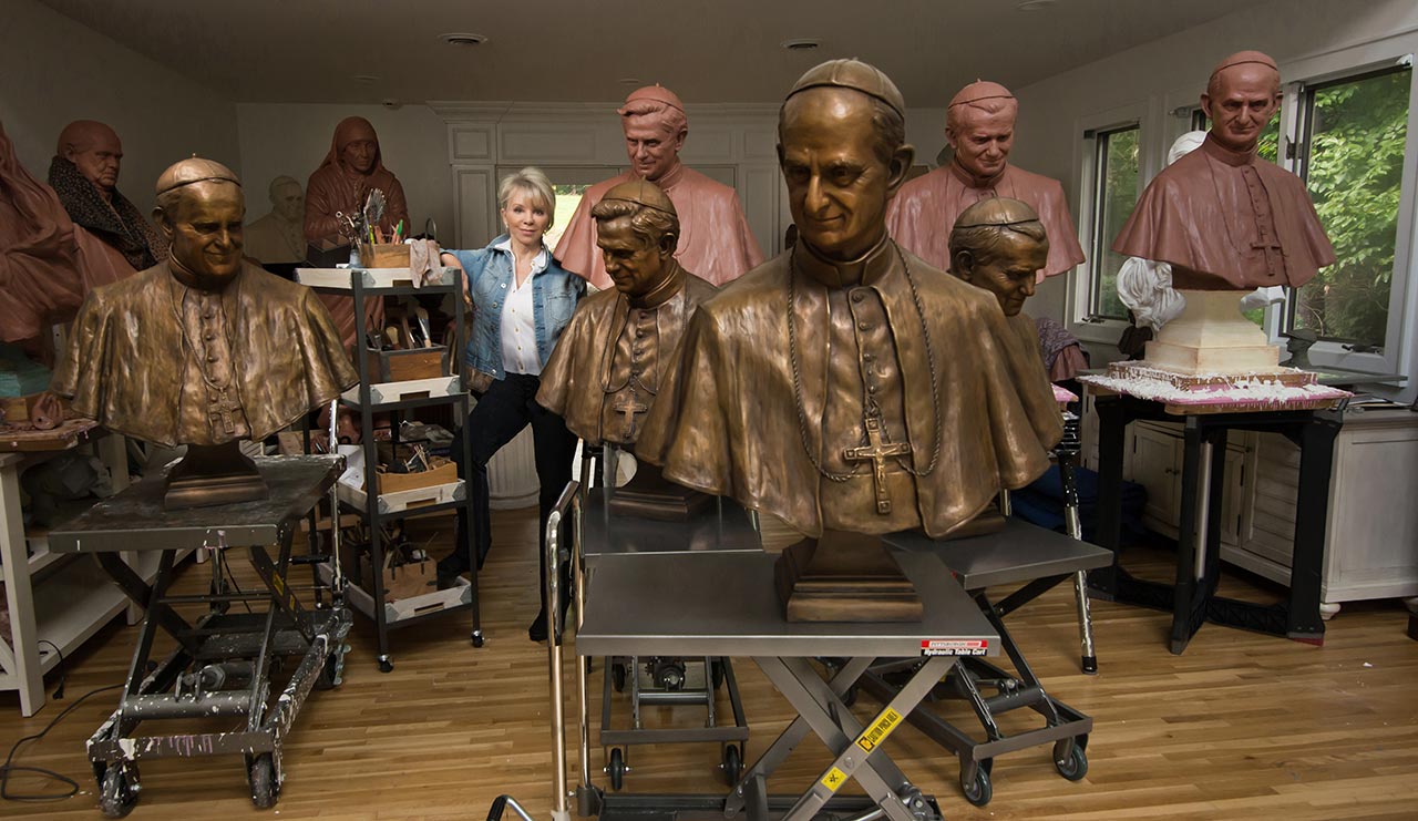 Carolyn D Palmer in studio with bronze sculptures