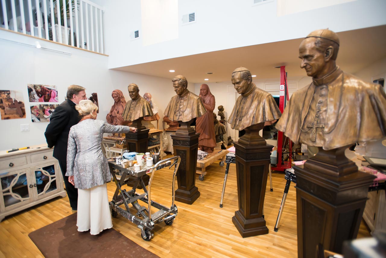 A group of people standing around statues in a room.