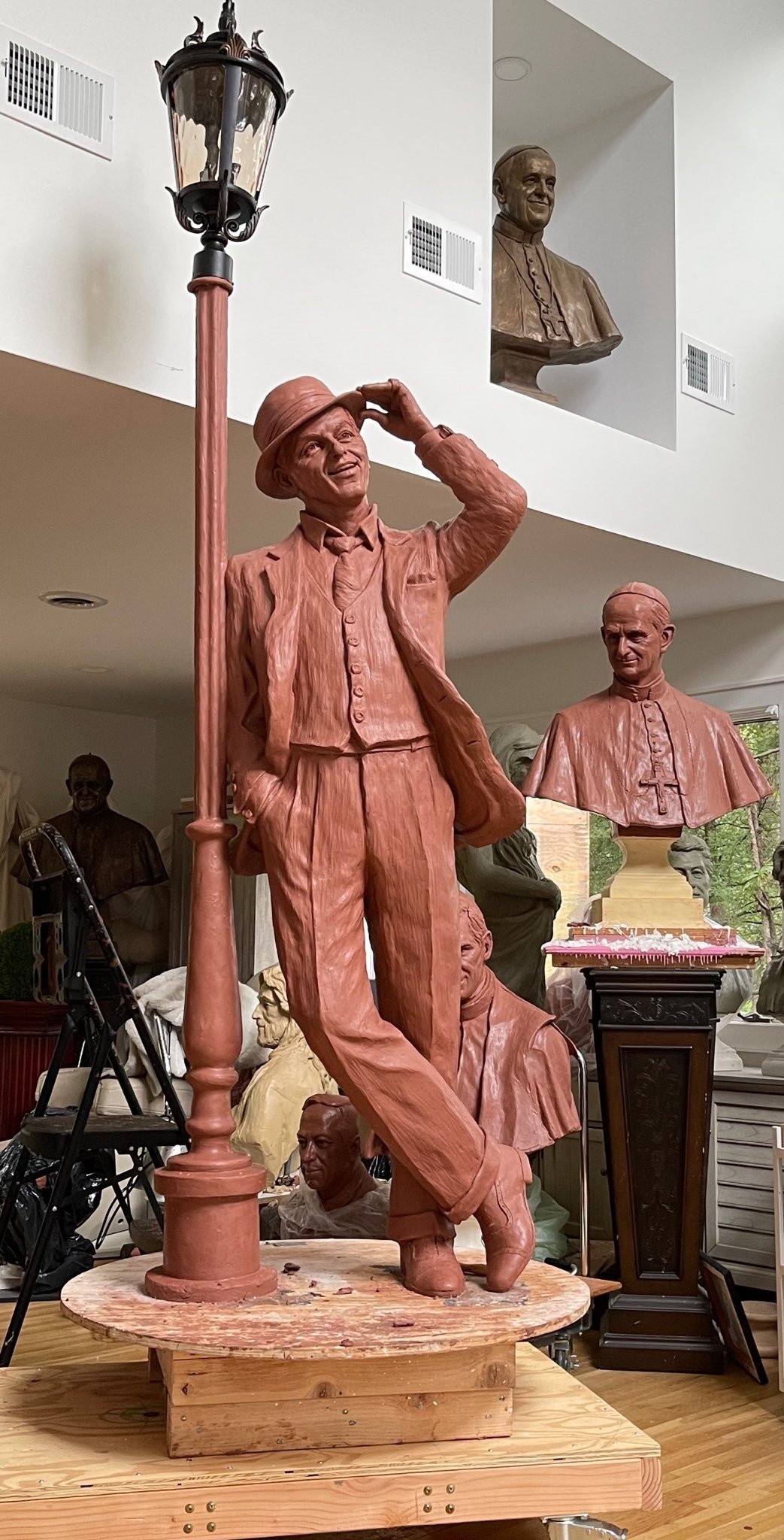 A statue of a man in brown clothes and hat.